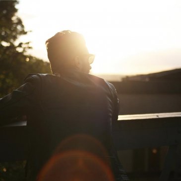 Man looking off into the distance while the sun sets