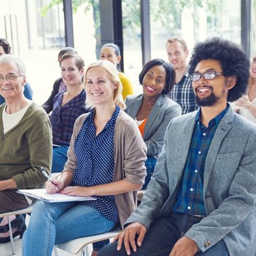 Image of many people sitting in their seats smiling