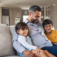 father with two kids on couch